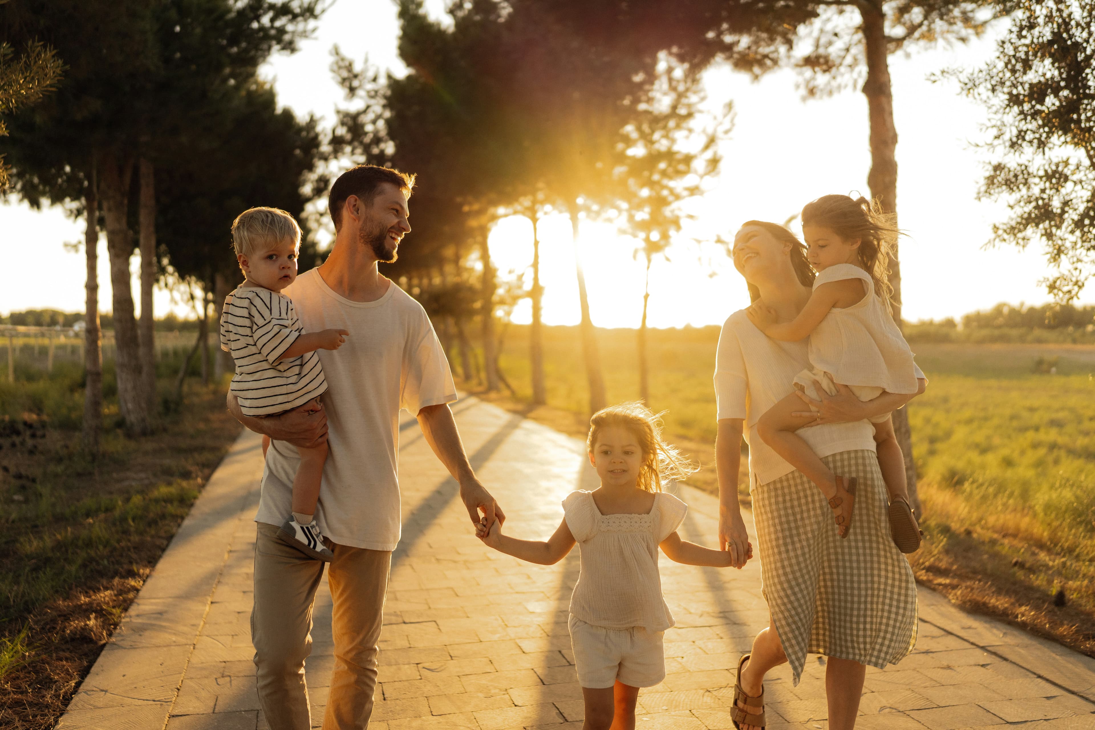 Familie spaziert bei Sonnenuntergang einen Weg entlang